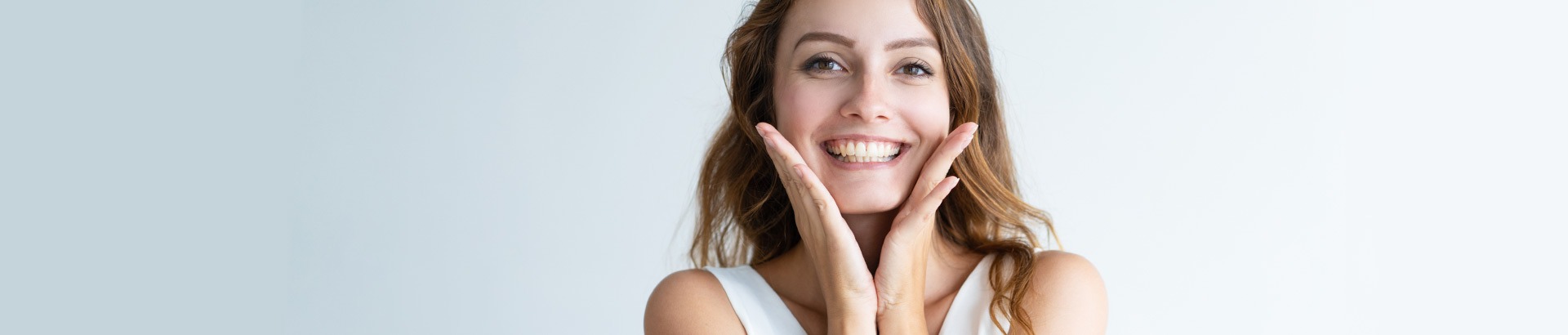 Happy young woman with radiant clear skin smiling and touching her face, exemplifying skin care success at DHL Skin Centre in Vijay Nagar Indore